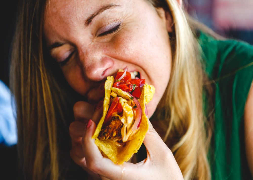 Girl eating a spicy taco.